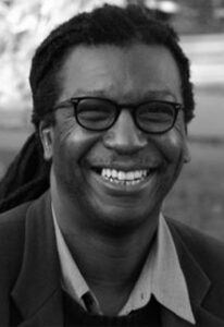 A black and white image of a black man smiling